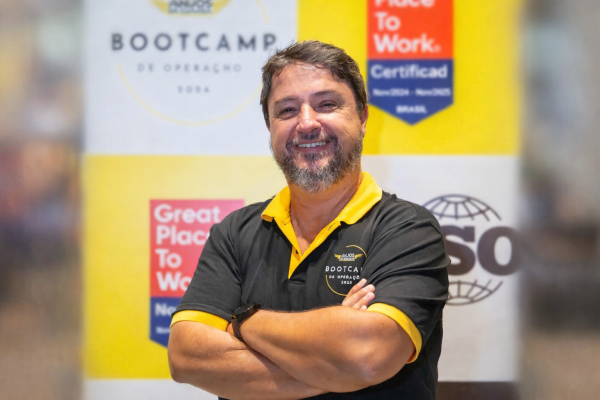 Homem sorrindo com camisa polo e logo